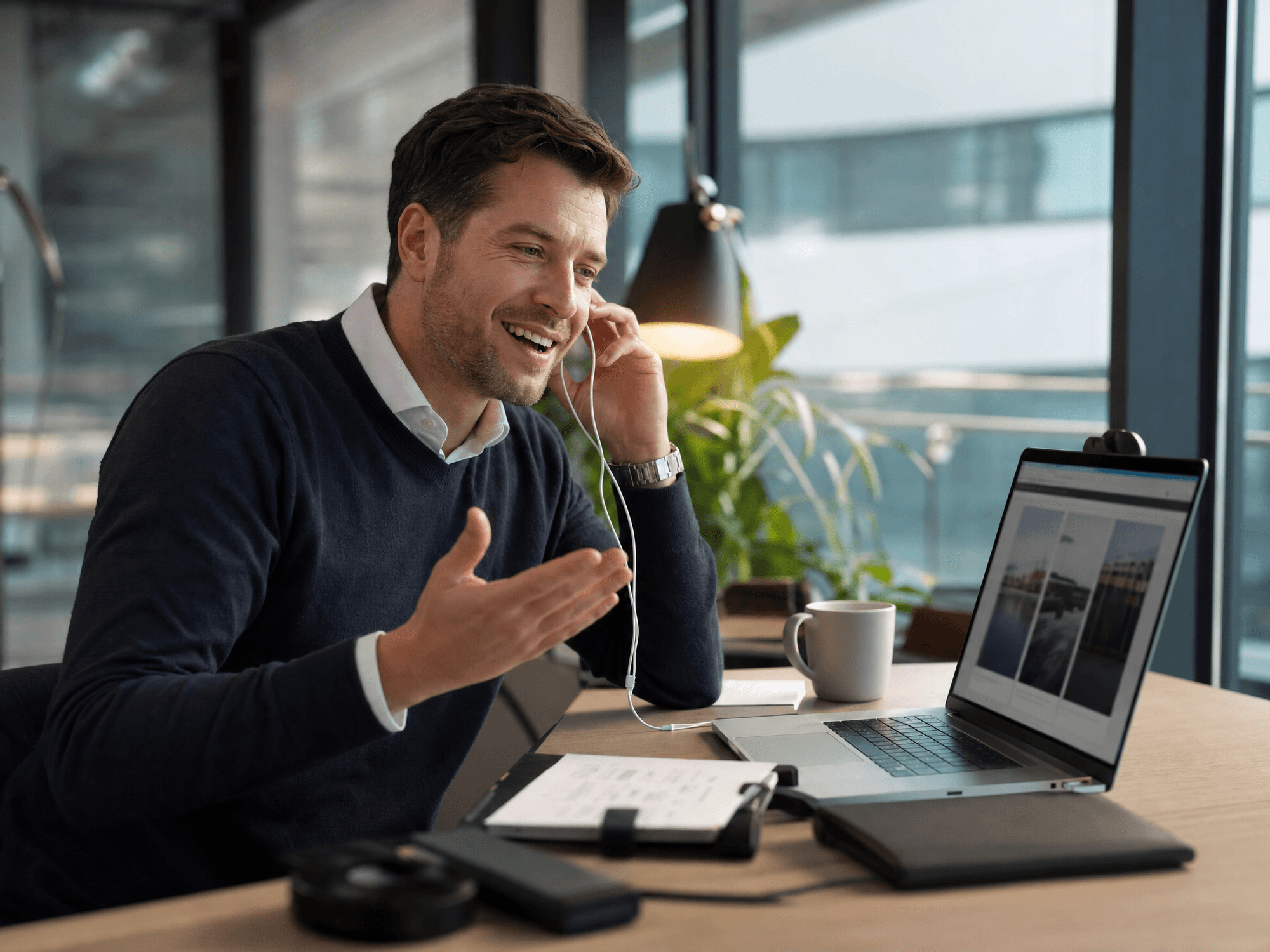 Editorial photo: a Western sales rep in a bright office on a call talking with a Western buyer, friendly, mid-conversation, a website on the laptop