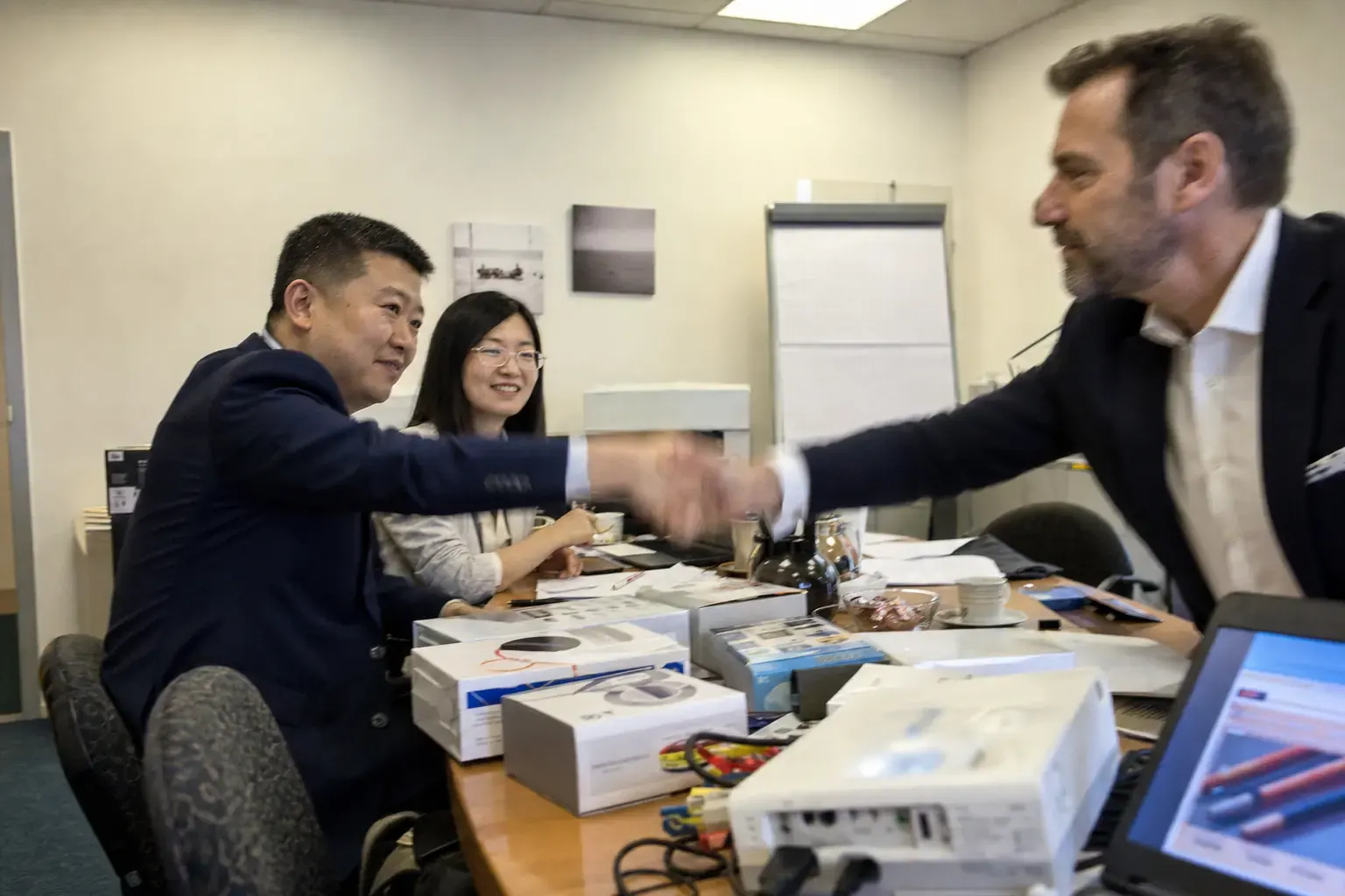 A Chinese exporter’s representative and an interpreter in a first meeting with a European buying director