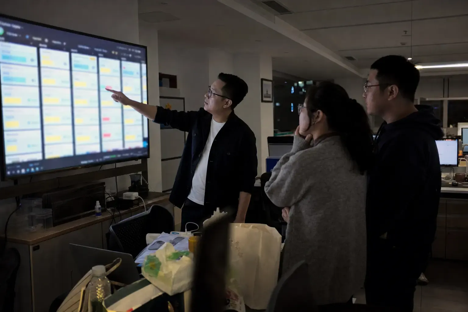 A Chinese export company’s sales team reviewing an overseas pipeline on a wall monitor at night